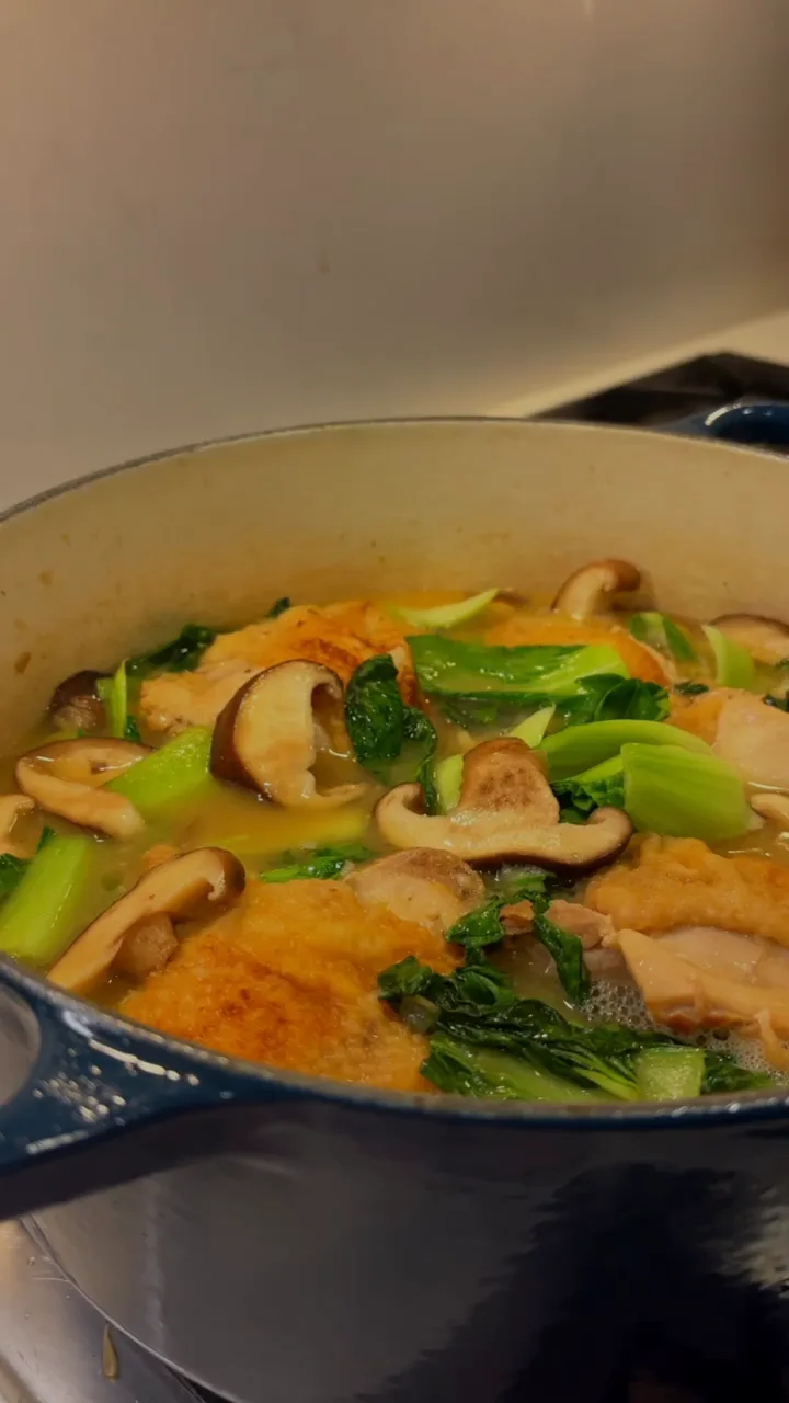 Golden chicken with mushrooms and greens in a Dutch oven