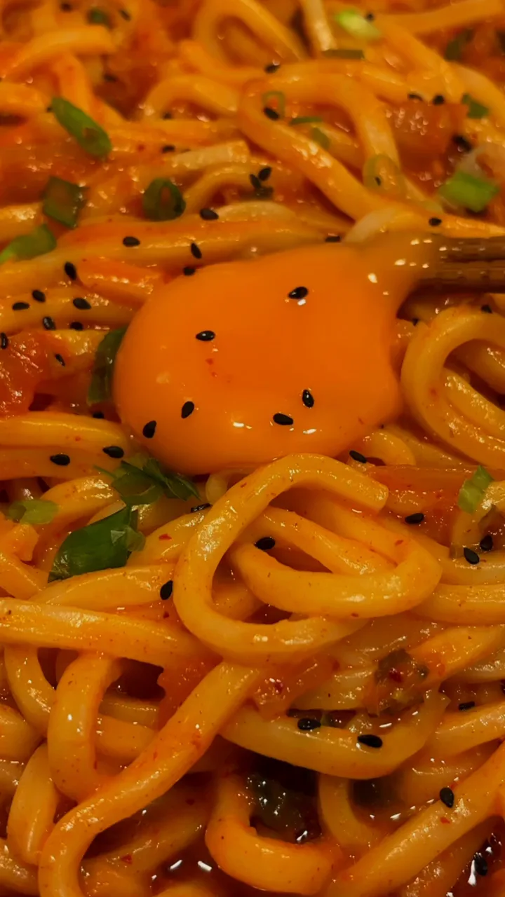 Saucy noodles topped with an egg and sesame seeds